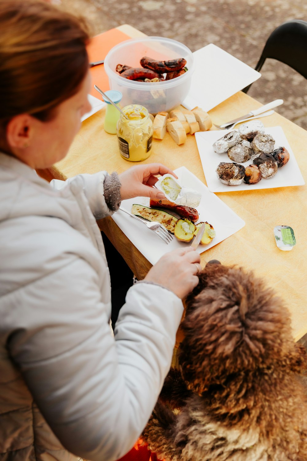 woman in white long sleeve shirt holding brown bread