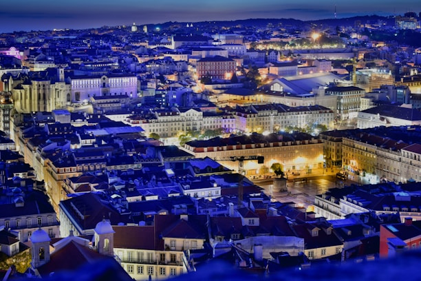 A vibrant cityscape with illuminated skyscrapers and busy streets at twilight, capturing a travel vibe.