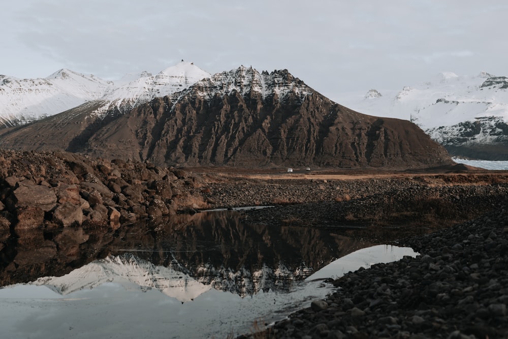 brown and white mountains near lake during daytime