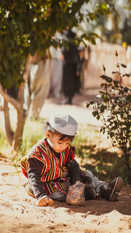 woman in red white and black plaid long sleeve shirt wearing white hat in Guerrara Algeria