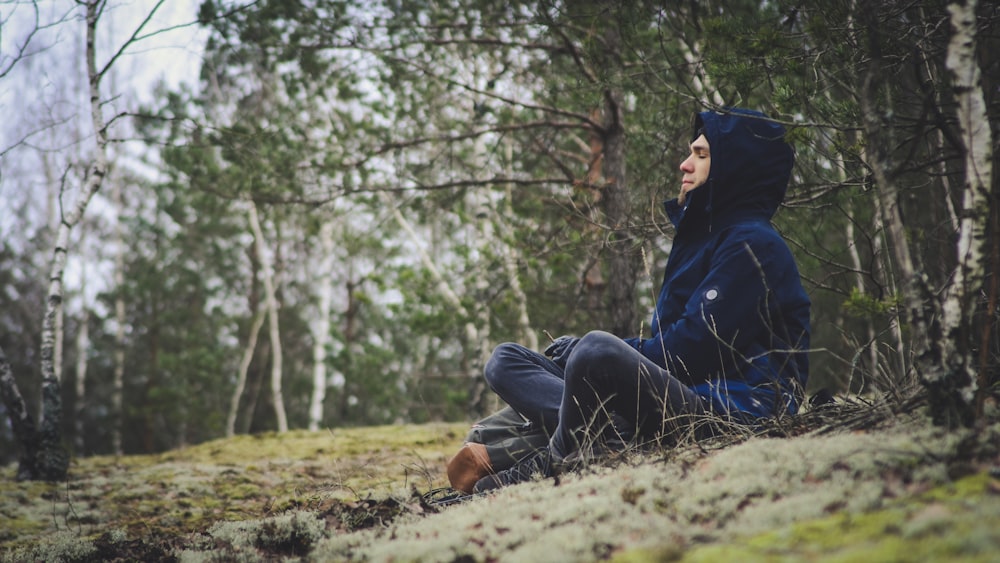 man in blue denim jeans and brown leather boots sitting on ground