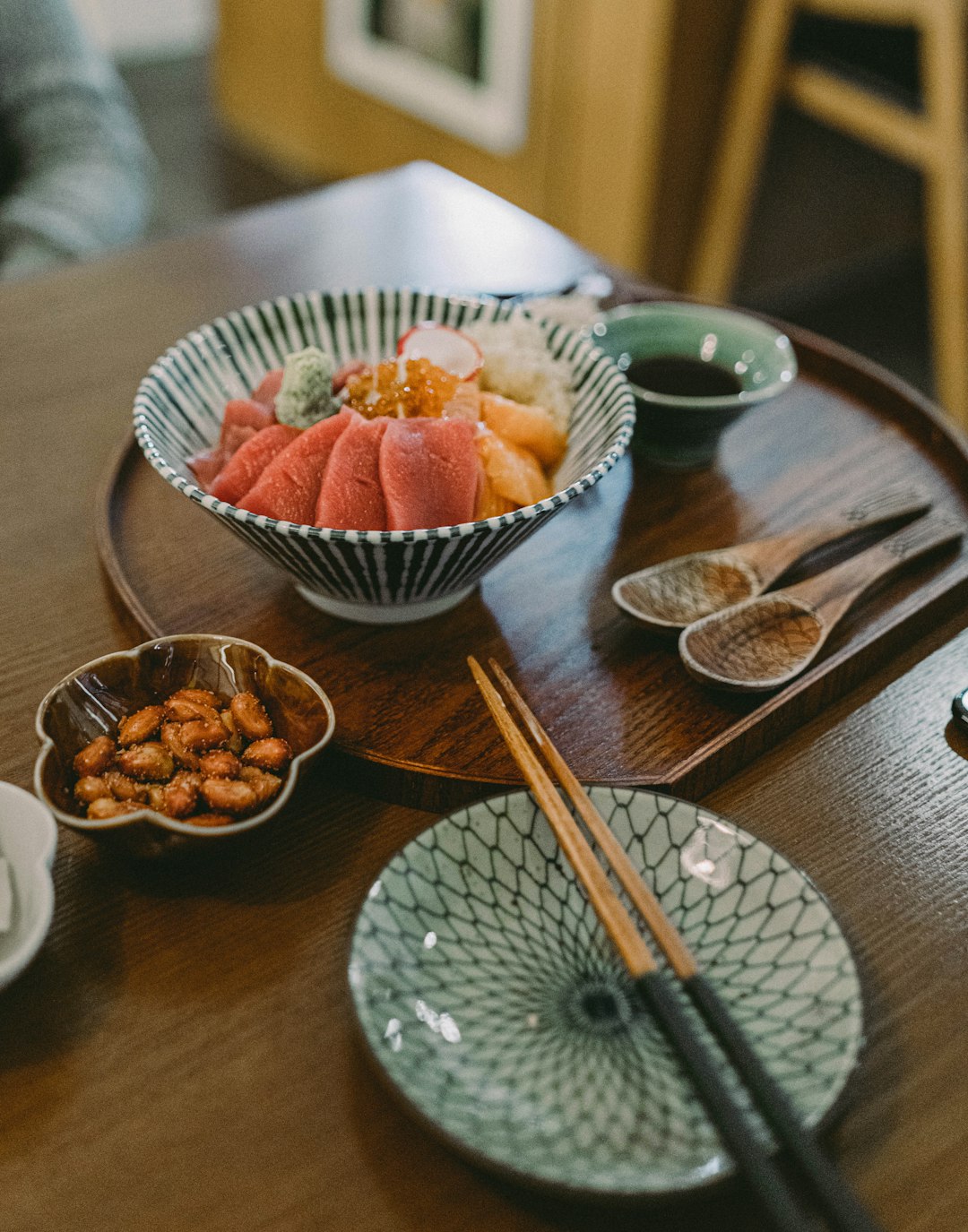 sliced strawberries on white ceramic bowl beside stainless steel fork and knife on round table