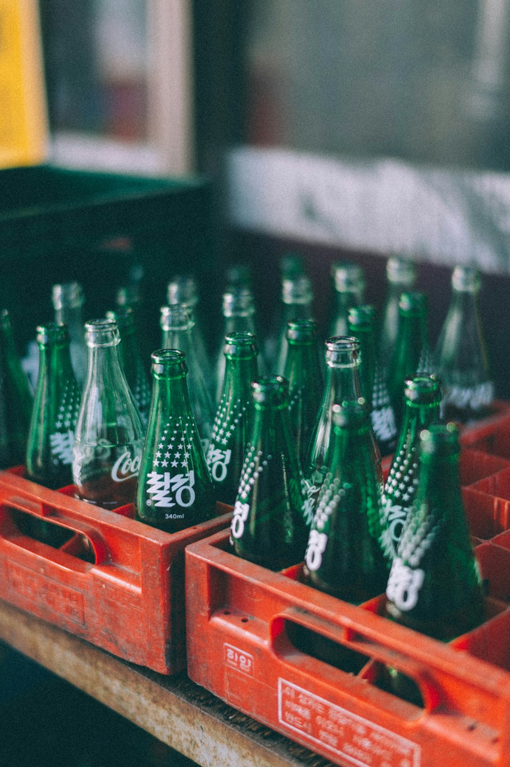 green glass bottles on red wooden shelf