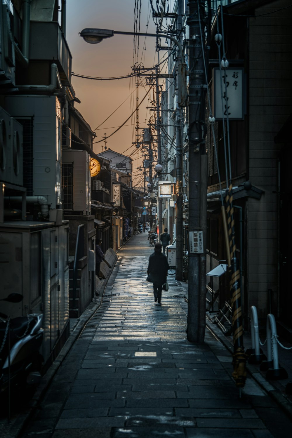 man in black jacket walking on sidewalk during daytime