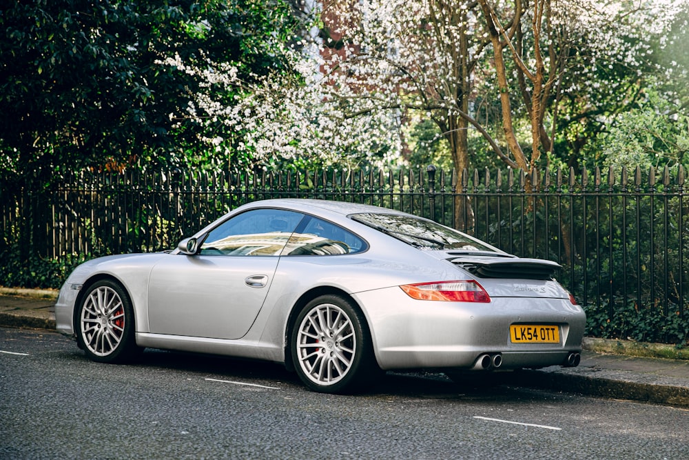 silver mercedes benz coupe parked on gray asphalt road during daytime