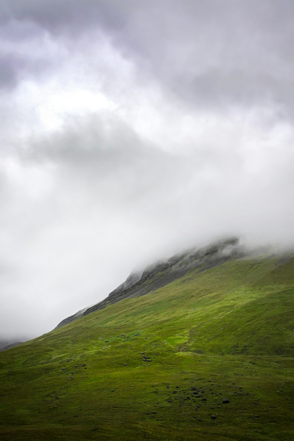 Grüner Berg unter weißen Wolken