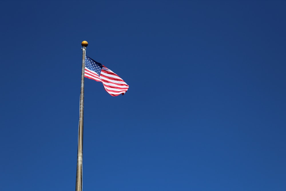 us a flag on pole under blue sky during daytime