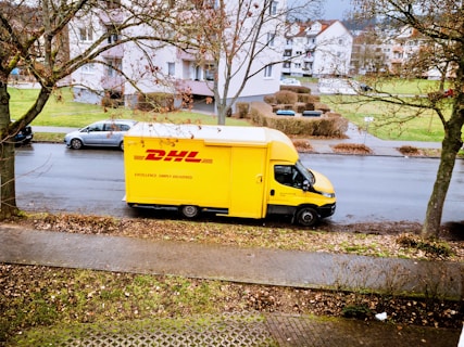 yellow and white box truck parked on sidewalk during daytime
