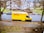 yellow and white box truck parked on sidewalk during daytime