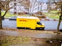 yellow and white box truck parked on sidewalk during daytime