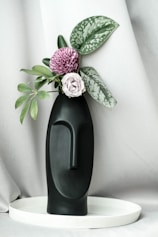 An aesthetic corner featuring a mix of plastic foliage in a modern vase.