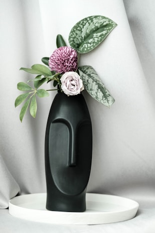 An aesthetic corner featuring a mix of plastic foliage in a modern vase.