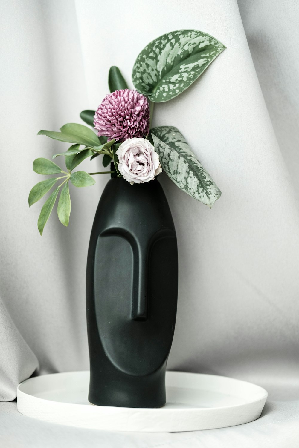 black and purple flower on black ceramic vase