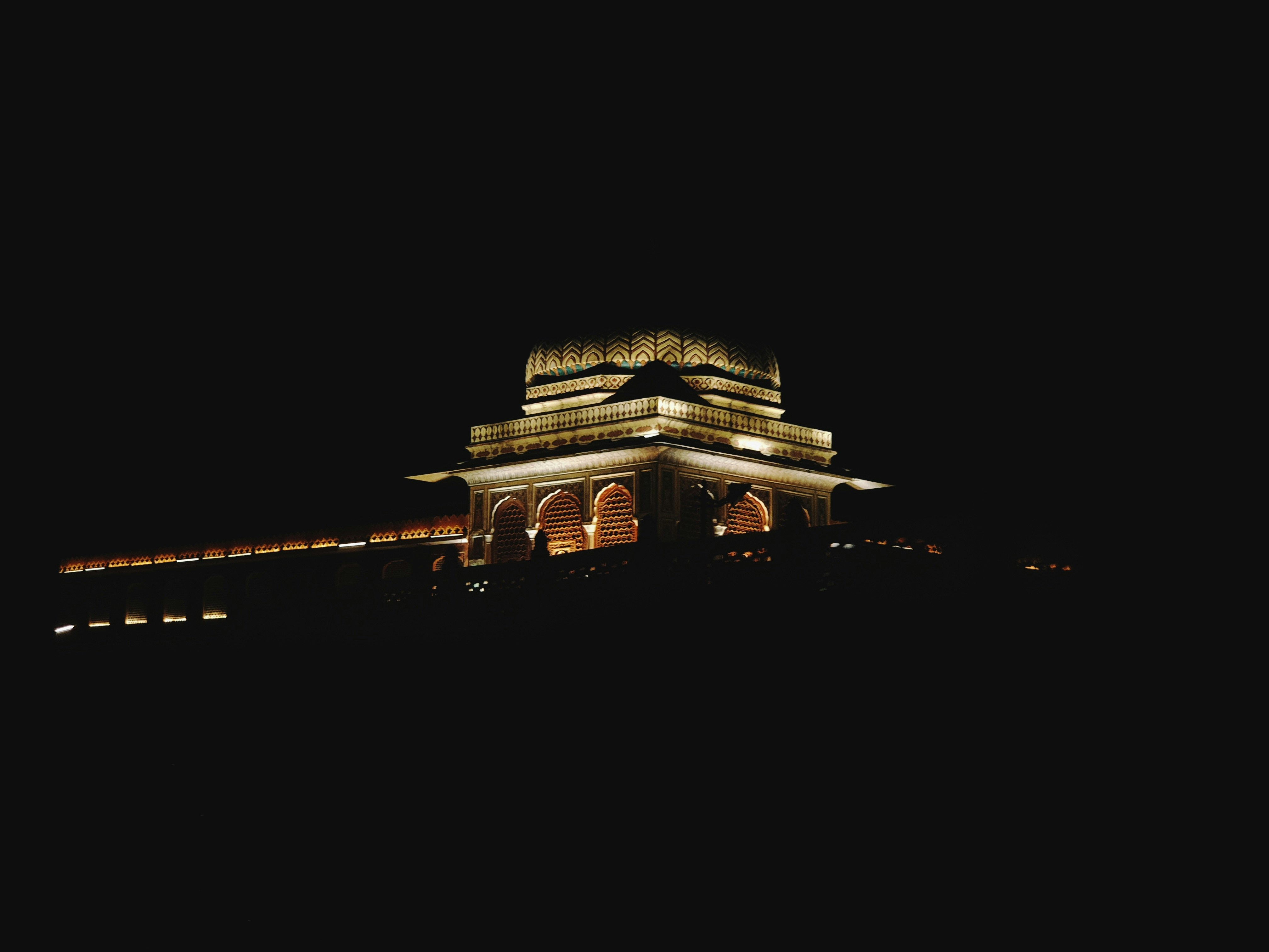 A well-lit photo of the Indian Parliament building, emphasizing its grand architecture.