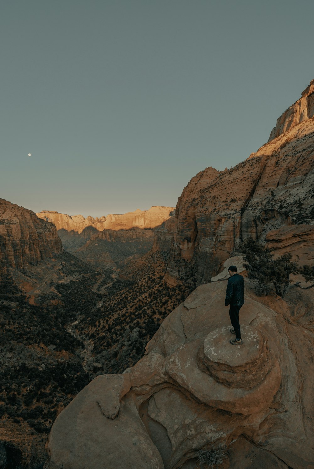 man in black jacket standing on rocky mountain during daytime