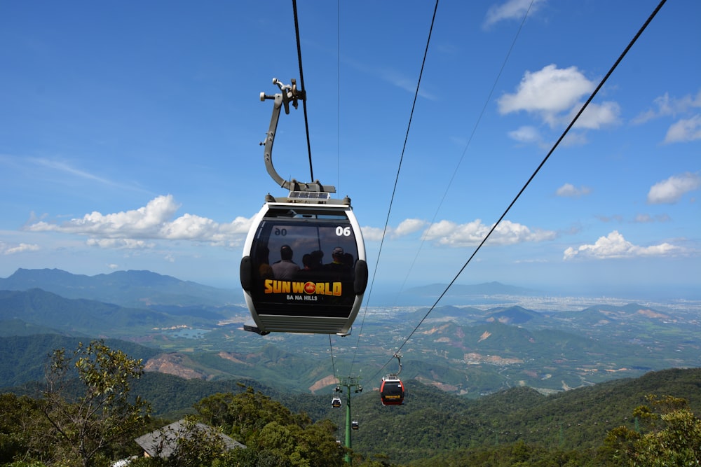 black cable car over green mountains during daytime