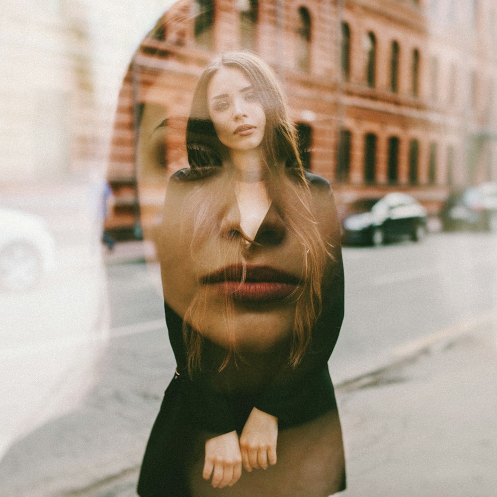 woman in black dress standing on road during daytime