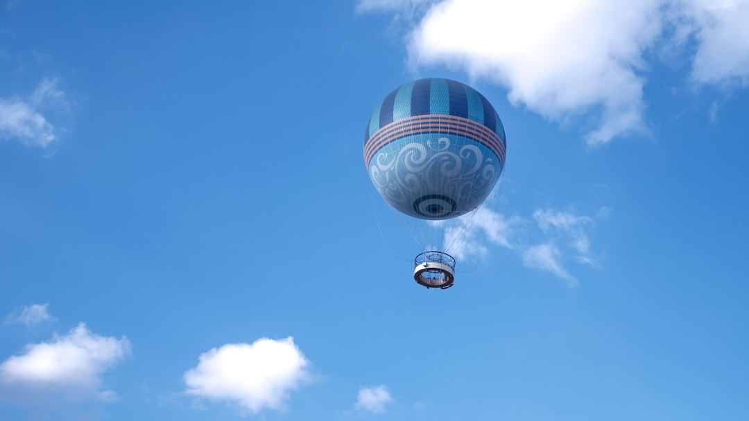 blue and white hot air balloon in mid air under blue sky during daytime