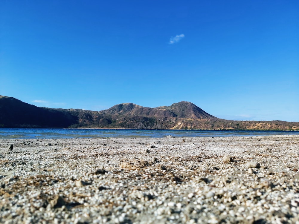 a rocky beach with a mountain range in the background