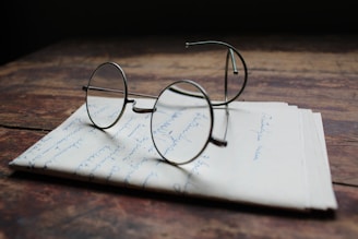 silver framed eyeglasses on white printer paper