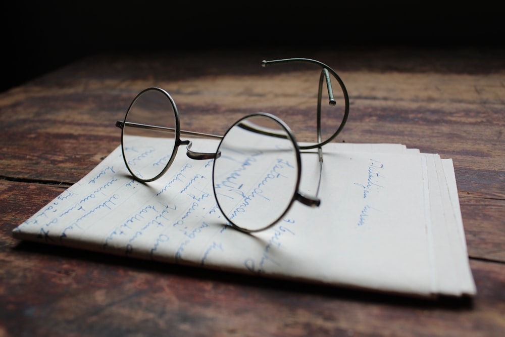 Lunettes à monture argentée sur papier d’imprimante blanc