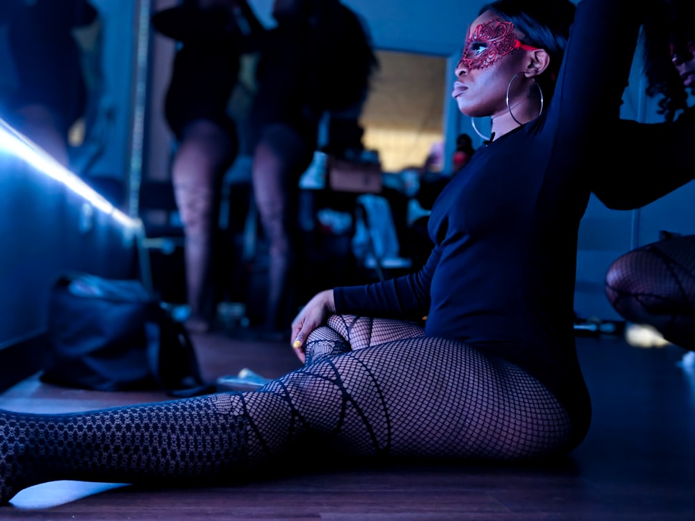 woman in black long sleeve shirt and black and white pants sitting on floor