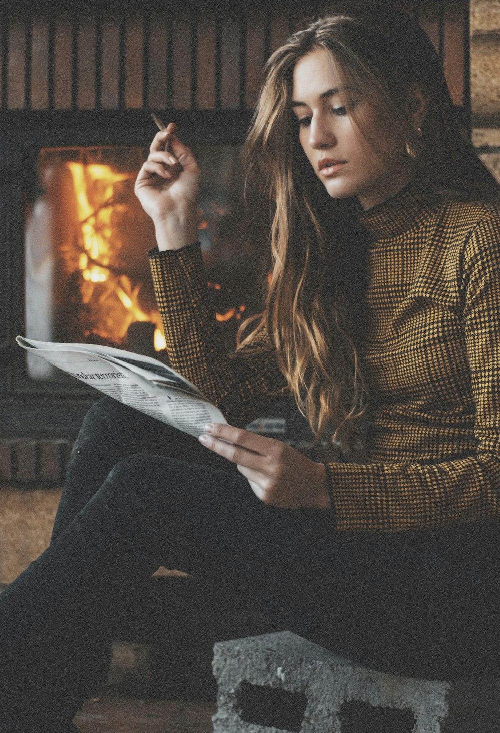 woman in brown and black plaid long sleeve shirt holding white paper