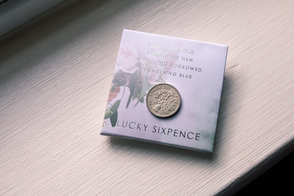 silver round coin on blue book