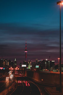 A cinematic still of a cityscape at dusk, with glowing streetlights and deep blues.