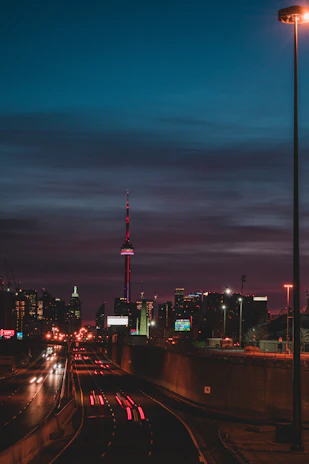 A cinematic still of a cityscape at dusk, with glowing streetlights and deep blues.