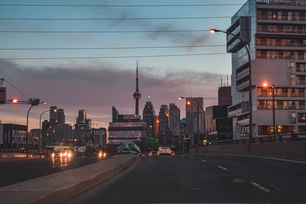 cars on road near high rise buildings during night time