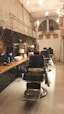 A stylish barber shop interior with vintage chairs and warm lighting.