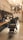 A stylish, modern barbershop interior with black leather chairs and a wooden counter. The walls feature black tiles and exposed pipes, with hanging lights providing a warm ambiance. Shelving holds various grooming products, and a large, arched window is visible at the back.
