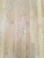 Close-up of a beautifully finished oak hardwood floor in a warmly lit modern living room.