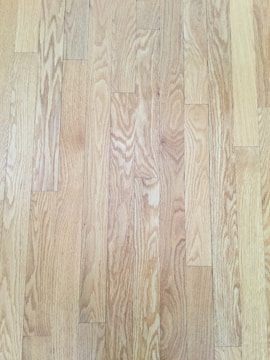 Close-up of a polished wooden floor reflecting light in a clean room.