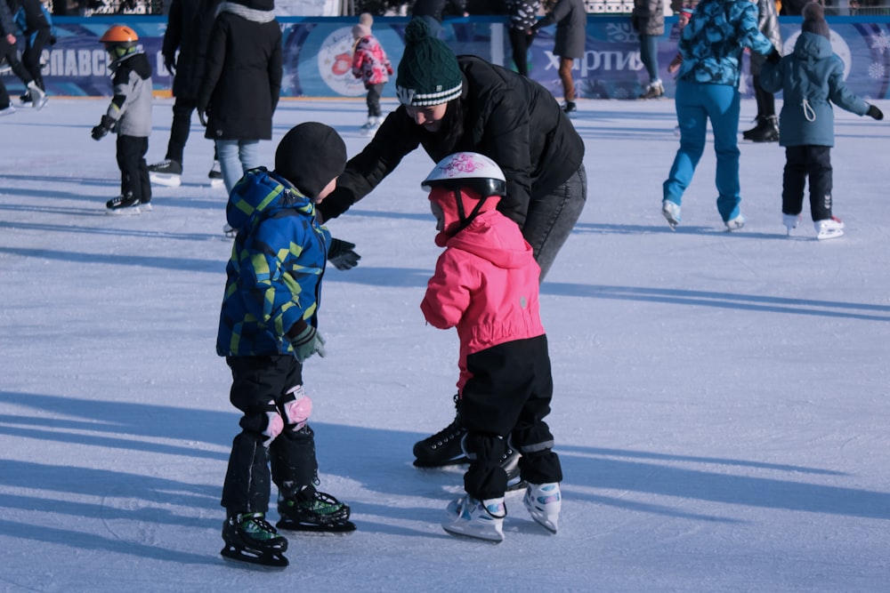 2 enfants en veste rouge et pantalon noir jouant au hockey sur glace