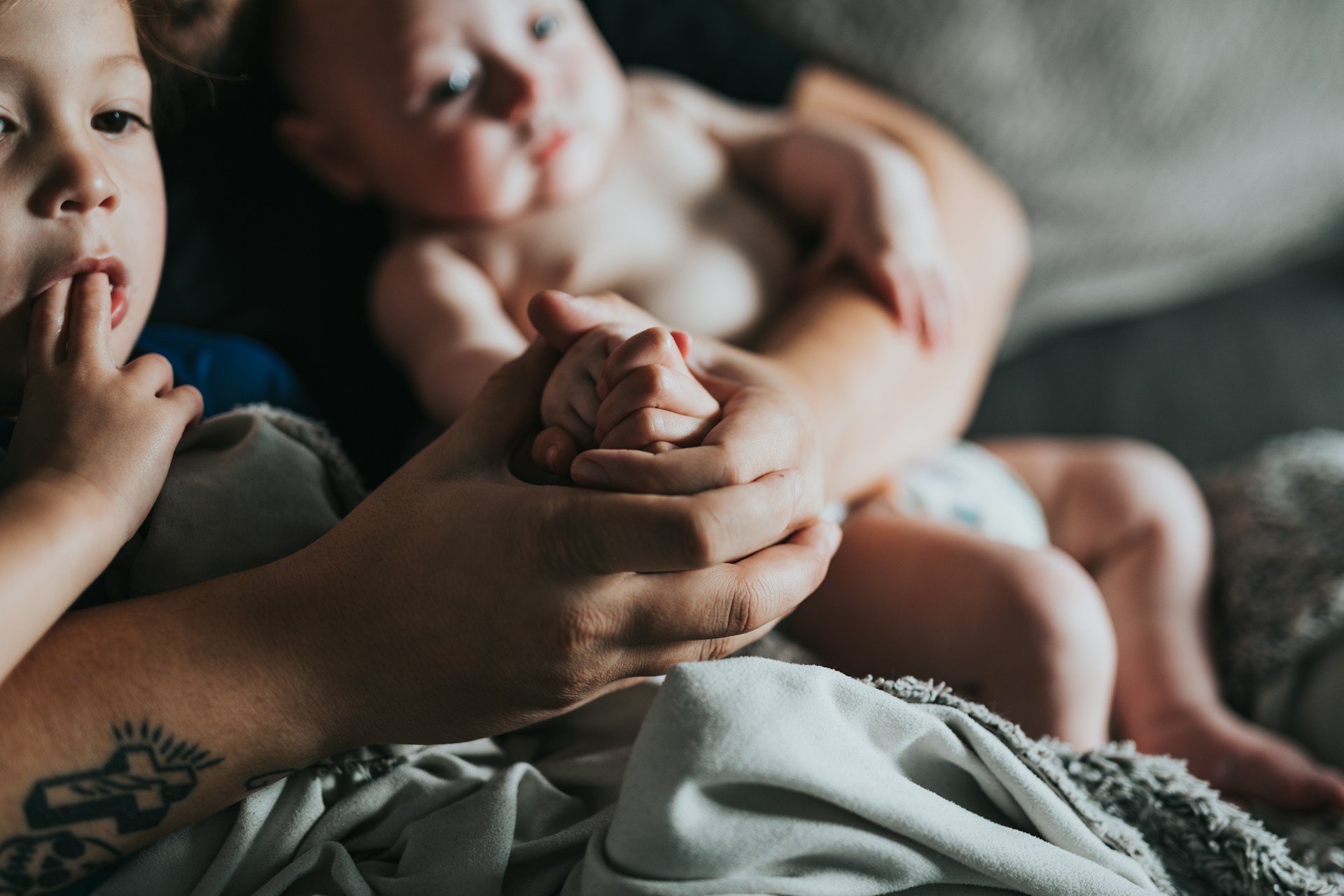 person holding baby on gray textile