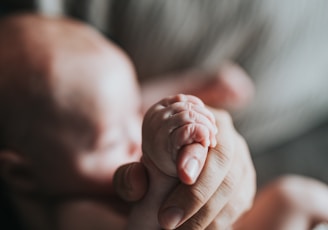 person holding babys feet