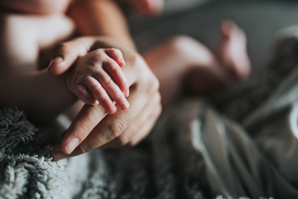 person holding babys feet