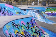 a group of skateboard ramps covered in graffiti