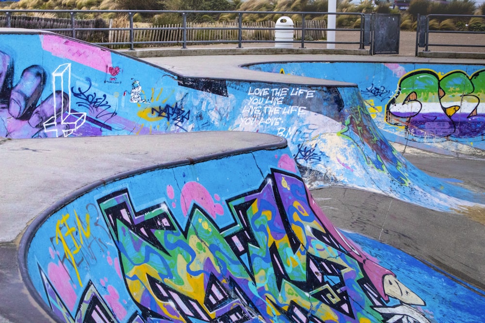 a group of skateboard ramps covered in graffiti