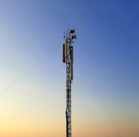 black electric post under blue sky during daytime