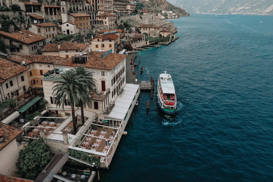 white and red boat on body of water near city buildings during daytime