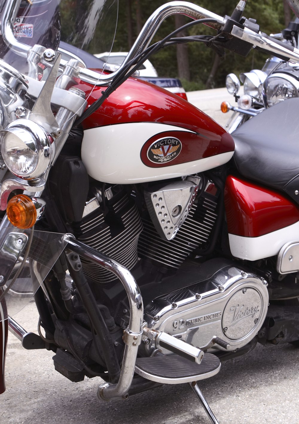 red and silver motorcycle near white car