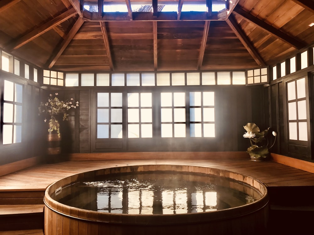 brown wooden round table near glass window