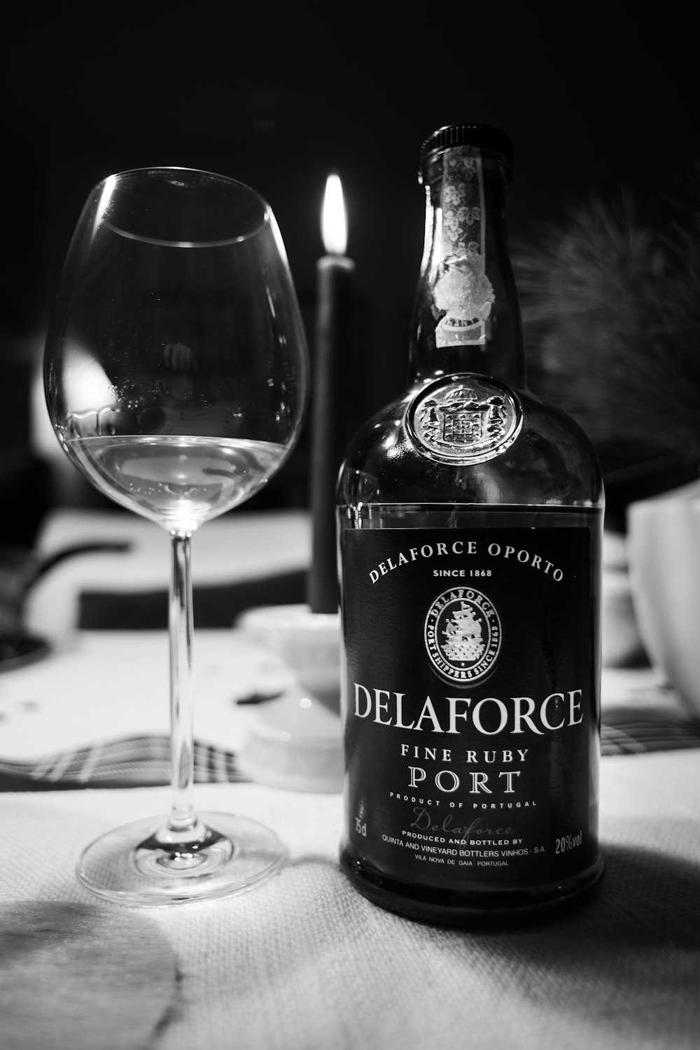 black and white labeled bottle beside clear wine glass