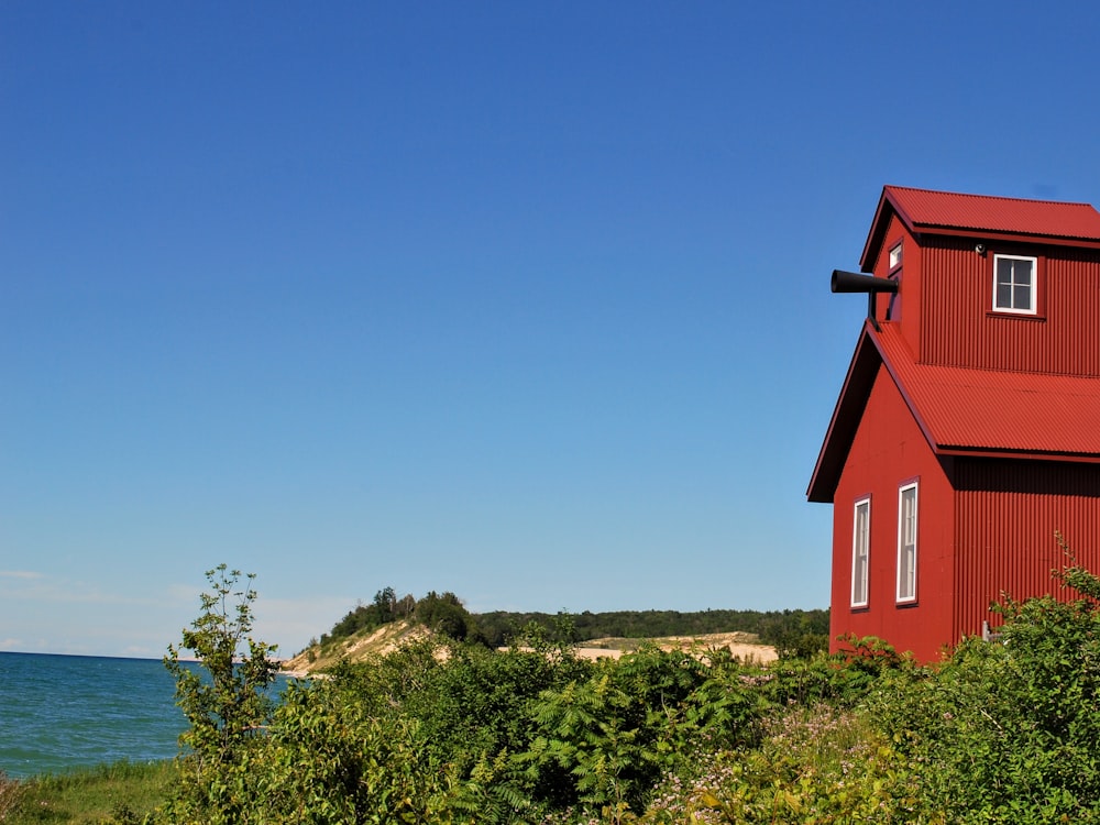 red and white concrete building near green trees under blue sky during daytime