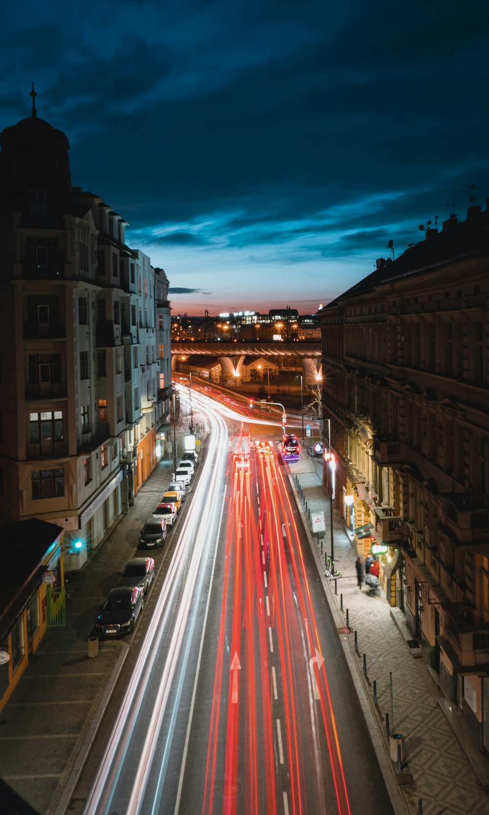 time lapse photography of cars on road between buildings during night time