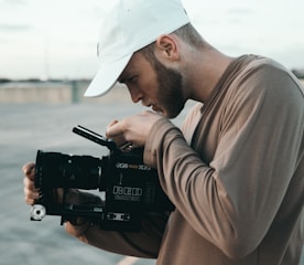 man in brown long sleeve shirt holding black dslr camera