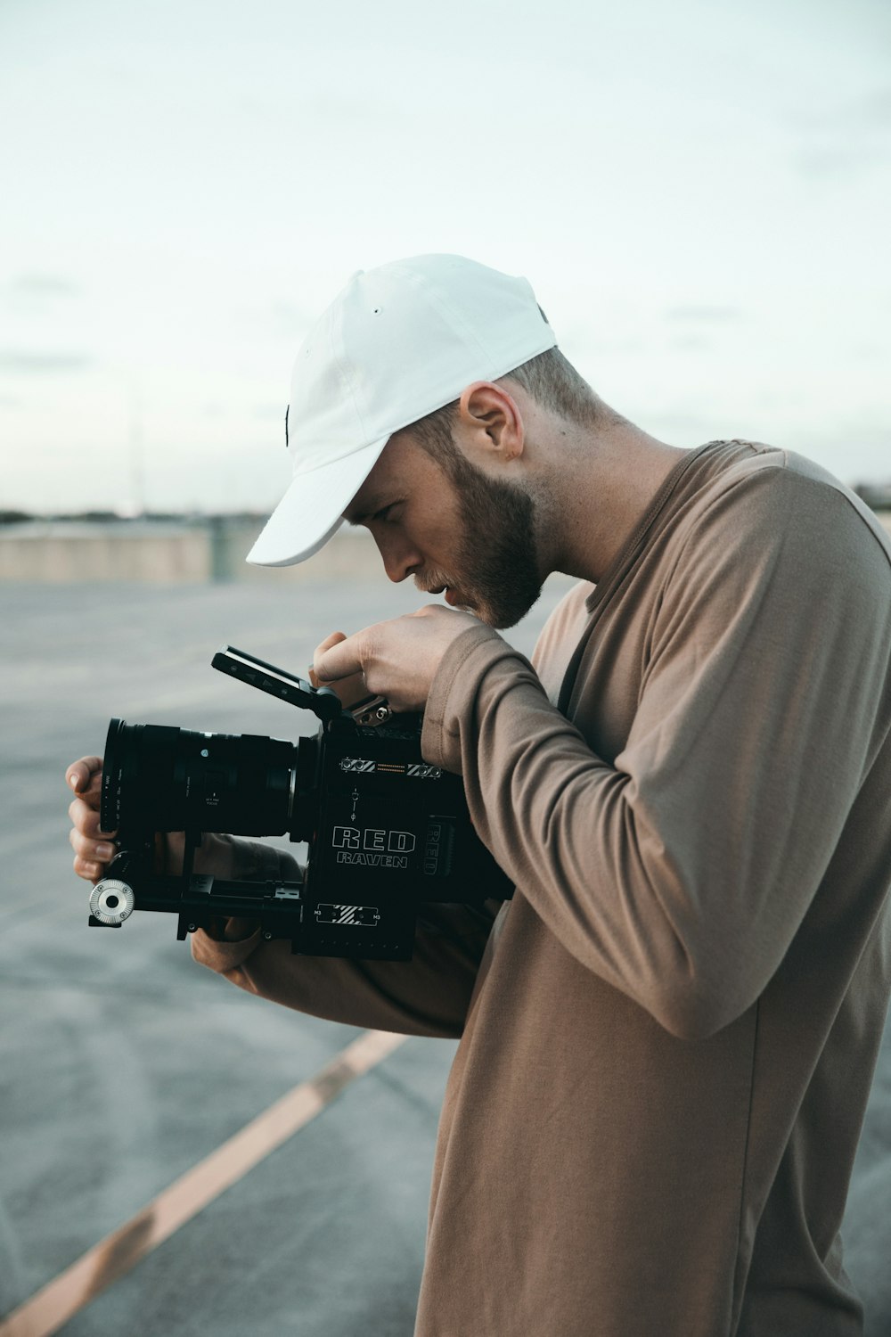 Mann im braunen Langarmhemd mit schwarzer DSLR-Kamera